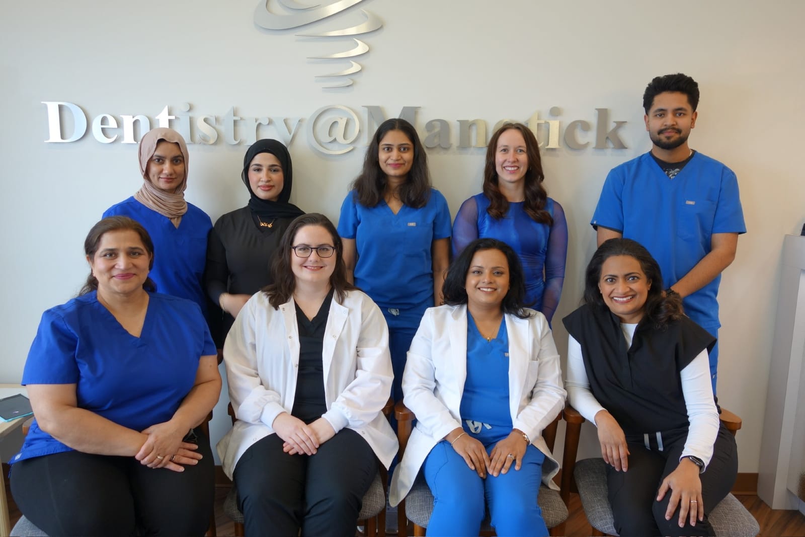 The Dentistry @ Manotick team gathered under the practice sign at 990 River Road